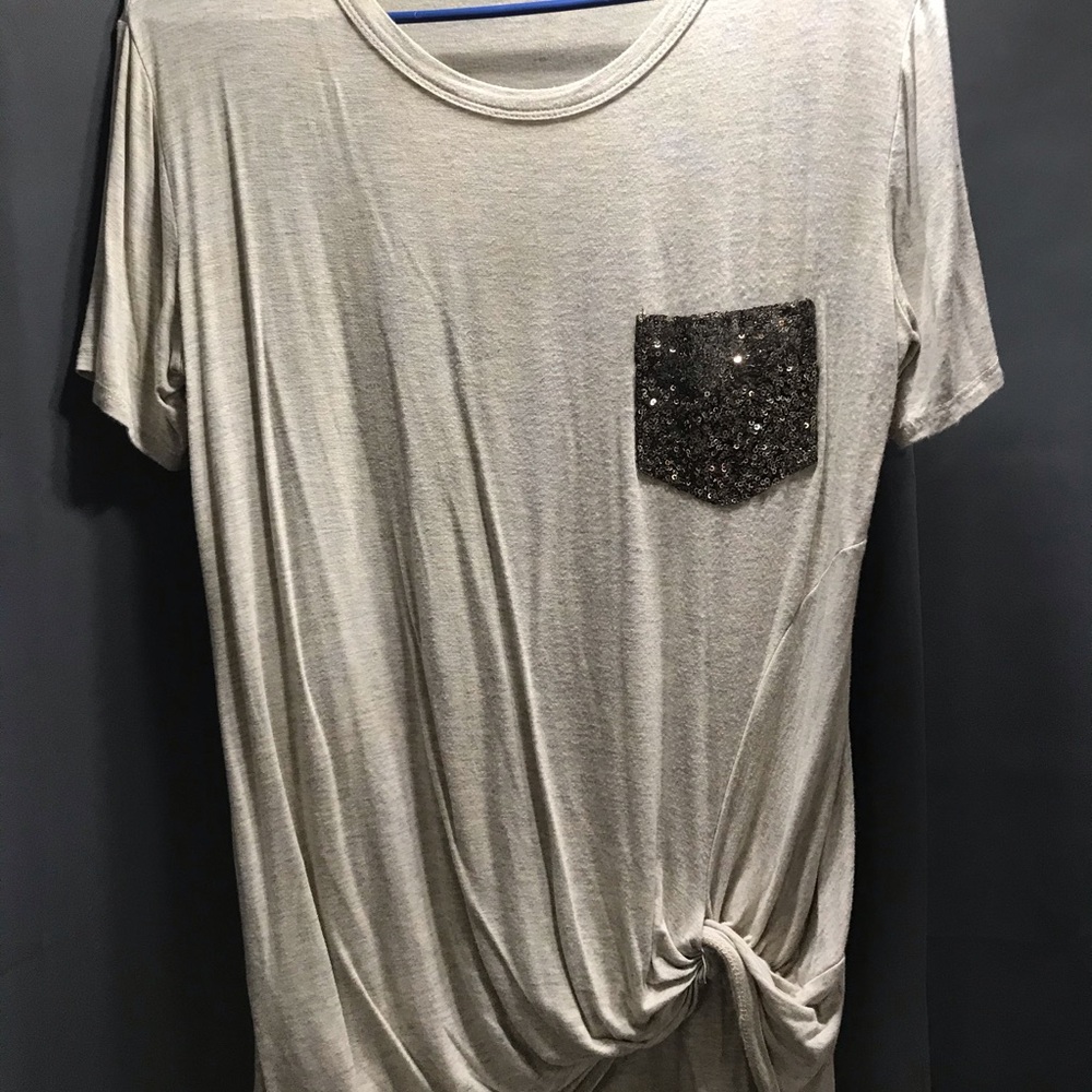 Soft t-shirt style top with decorative pocket and gathered bottom